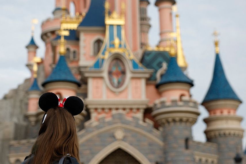 Visitante con las emblemáticas orejas de Mickey y Minnie Mouse observa al castillo inspirado en la Bella Durmiente en el Parque Disneyland París, en Marne-la-Vallée, al este de París, el 16 de octubre de 2023.&nbsp;