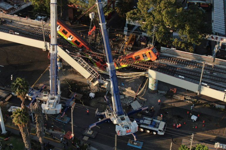 Vista aérea de vagones del metro colgando desde una sección elevada colapsada en la Ciudad de México, el martes 4 de mayo de 2021. La sección elevada del metro de la Ciudad de México colapsó el lunes por la noche matando al menos a 23 personas.