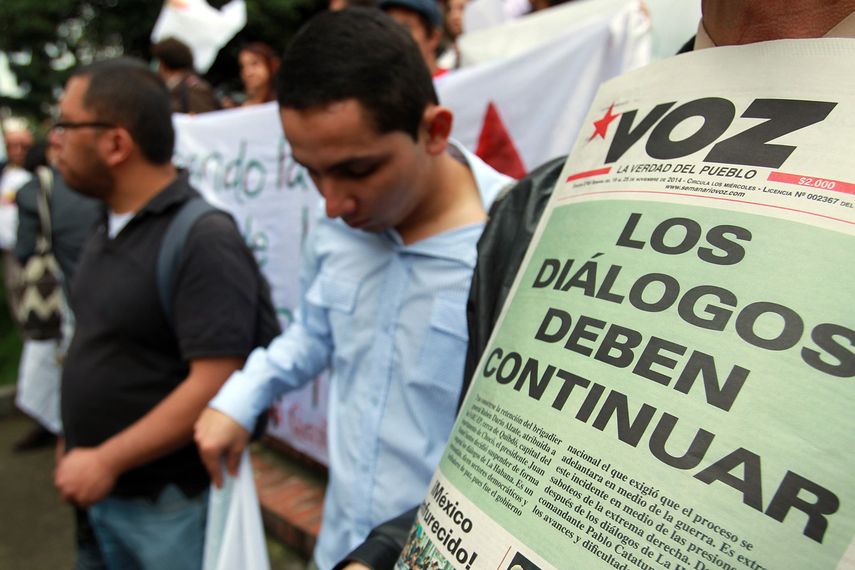 Manifestantes convocados por partidos de izquierda y organizaciones sociales sostienen carteles durante una protesta hoy, miércoles 19 de noviembre de 2014, en Bogotá (Colombia). Los manifestantes exigieron al Gobierno colombiano que mantenga las conve