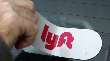 Un conductor en Pittsburgh pone el logotipo de Lyft en su auto.