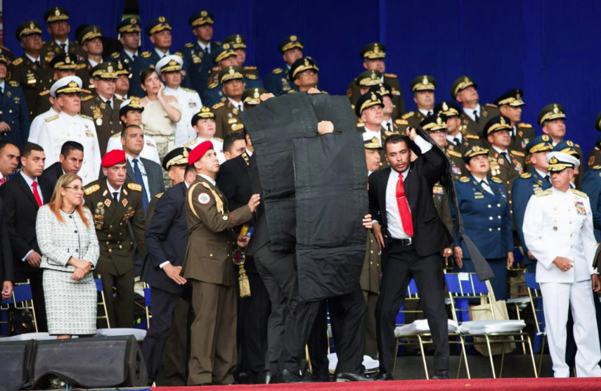 Escoltas de Nicolás Maduro lo protegen con laminas antibalas luego de escucharse una explosiones.&nbsp;