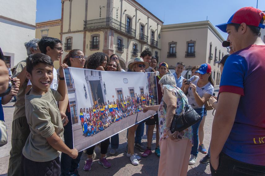 Un grupo de venezolanos residente en México observan la fotografía tomada a la diáspora.&nbsp;