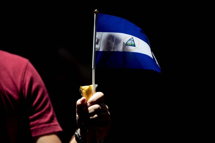 Un joven sostiene una bandera de Nicaragua en forma de protesta contra el gobierno de Daniel Ortega.