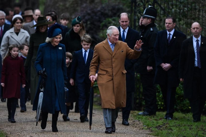El rey Carlos III flanqueado por la reina consorte Camilla saludan a los miembros del público cuando llega al tradicional servicio de Navidad de la familia real en la iglesia de Santa María Magdalena en Sandringham, Norfolk, este de Inglaterra, el 25 de diciembre 2022.