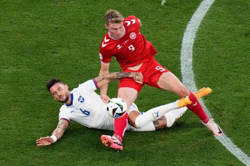 Rasmus Hojlund (derecha), de la selección de Dinamarca, y Nemanja Gudelj, de Serbia, disputan un balón durante el partido de la Eurocopa realizado el martes 25 de junio de 2024.