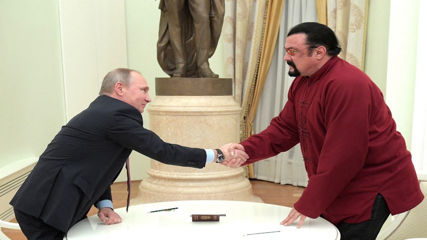En esta foto de archivo tomada el 25 de noviembre de 2016, el presidente de Rusia, Vladimir Putin, le da la mano al actor de acción estadounidense Steven Seagal después de presentarle un pasaporte ruso durante una reunión en el Kremlin en Moscú.