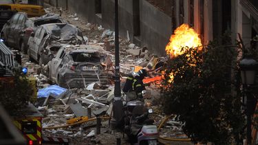 Bomberos trabajan para sofocar un incendio junto a un edificio dañado por una explosión en el centro de Madrid, el miércoles 20 de enero de 2021.&nbsp;