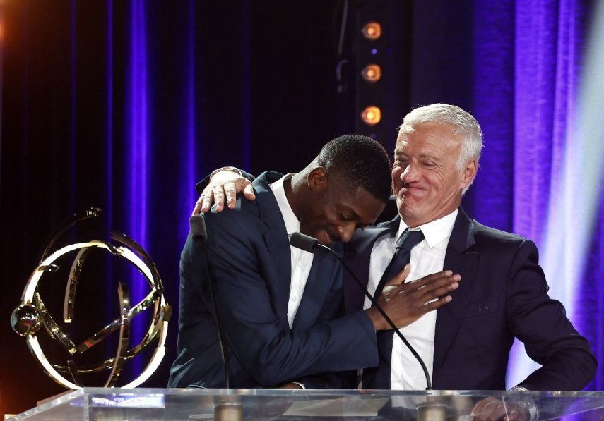 El delantero francés #10 del Paris Saint-Germain (PSG) , Ousmane Dembélé, reacciona tras recibir el premio al Mejor Jugador de la Ligue 1 francesa de manos del seleccionador francés, Didier Deschamps (der.), durante la ceremonia televisada de entrega de trofeos de la UNFP (Unión Nacional de Futbolistas Profesionales de Francia), en París el 11 de mayo de 2025.&nbsp;