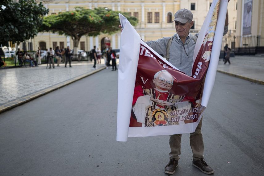 Un hombre abre una pancarta con la imagen del Papa León XIV frente a la catedral de Chiclayo, en el norte de Perú, el 9 de mayo de 2025. El pontífice León XIV, nacido en Estados Unidos y cercano al Papa Francisco, se nacionalizó peruano en 2015 y dedicó más de 20 años como misionero en el país andino.