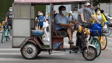   Unas personas que portan mascarillas esperan para cruzar una calle en Pekín, el miércoles 17 de junio de 2020.  