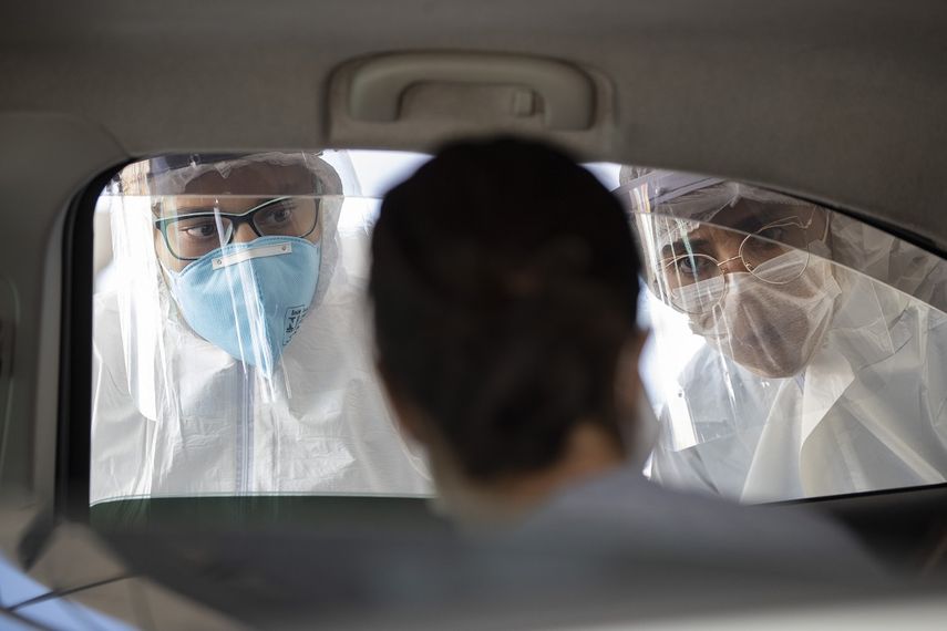 En esta imagen, tomada el 30 de marzo de 2020, personal m&eacute;dico entrevistan a una persona en el interior de un auto para comprobar si padecen s&iacute;ntomas de coronavirus, en Guarulhos, a las afueras de Sao Paulo, Brasil.