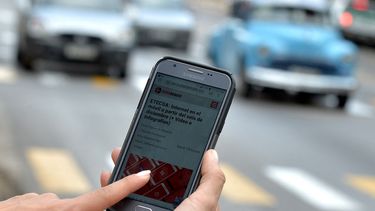 Una mujer usa su teléfono móvil para conectarse a internet mediante wifi en La Habana, el 5 de diciembre de 2018. Los cubanos tendrán la oportunidad de tener internet en sus teléfonos móviles desde el jueves, pero a tarifas más altas.