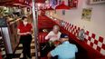 Una empleada de un restaurante atiende a clientes.