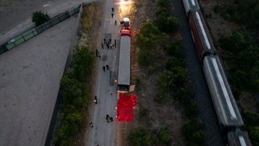 En esta vista aérea, agentes del orden investigan un tráiler el 27 de junio de 2022 en San Antonio, Texas. Según informes, al menos 46 personas, presuntamente trabajadores migrantes mexicanos, fueron halladas muertas en un tráiler abandonado. Más de una docena de víctimas fueron halladas con vida, sufriendo un golpe de calor, y trasladadas a hospitales locales.&nbsp;