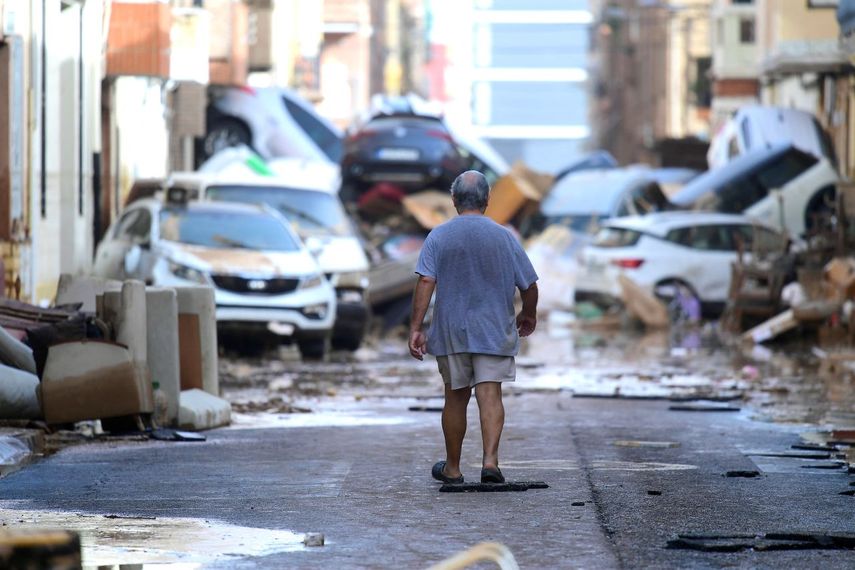 Un hombre camina cerca de coches apilados tras las inundaciones mortales en Sedavi, al sur de Valencia, en el este de España, el 30 de octubre de 2024.