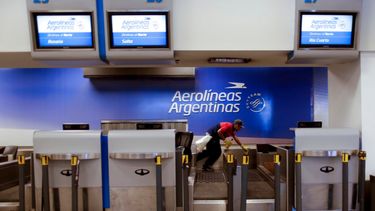 Un trabajador limpia el mostrador de facturación de Aerolíneas Argentinas en el aeropuerto de Buenos Aires, Argentina.