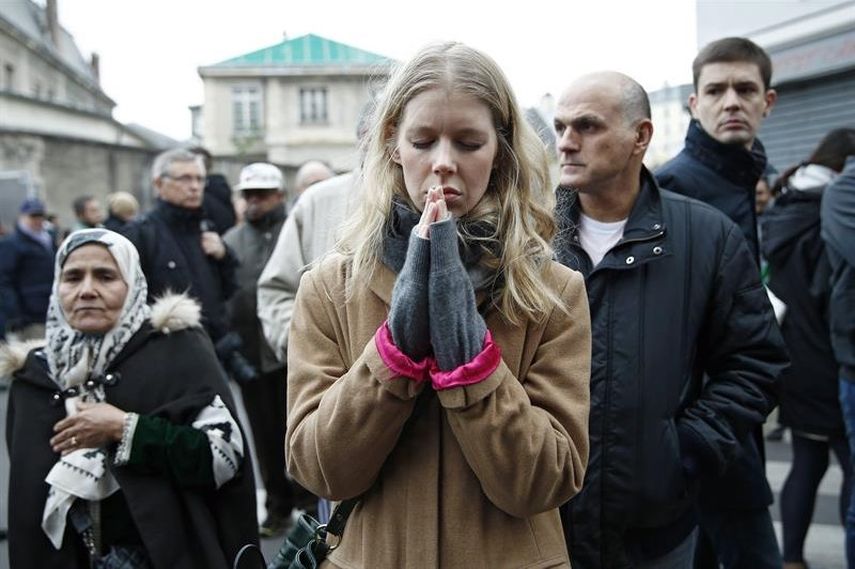 Un grupo de personas se congregó a manifestar su dolor frente al café Carrillon de Paris, uno de los lugares del atentado (EFE)