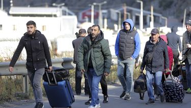 Un grupo de ciudadanos rusos caminan con su equipaje tras cruzar la frontera en Verkhny Lars, entre Georgia y Rusia en Georgia, el 27 de septiembre de 2022.&nbsp;