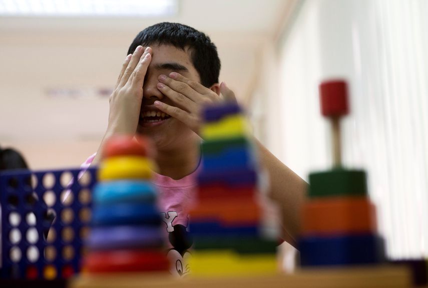 Un niño con autismo juega en durante una clase de aprendizaje básico.