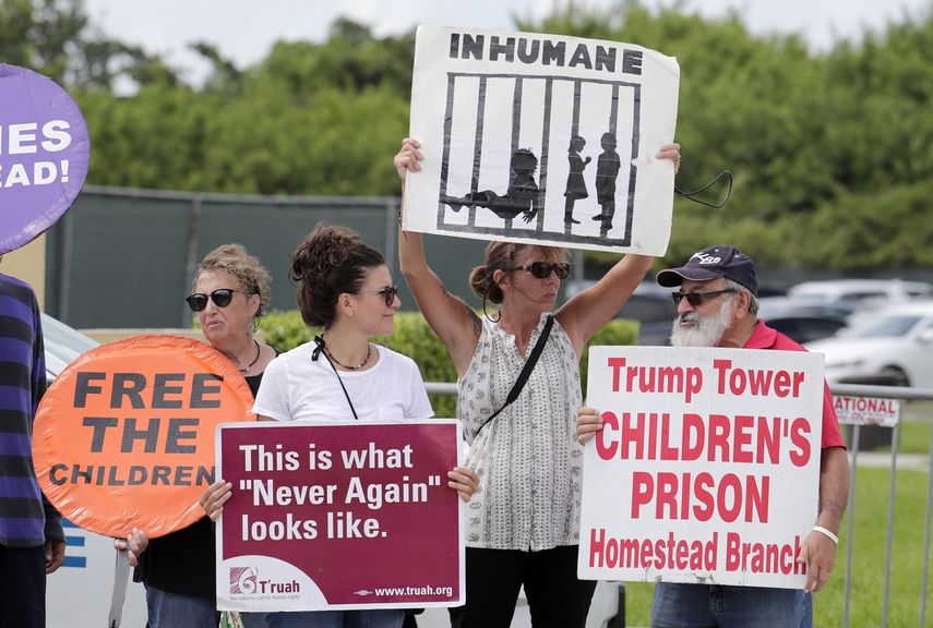 Manifestantes sostiene pancartas afuera de un albergue para ni&ntilde;os migrantes no acompa&ntilde;ados en Homestead, Florida, el 15 de julio de 2019.