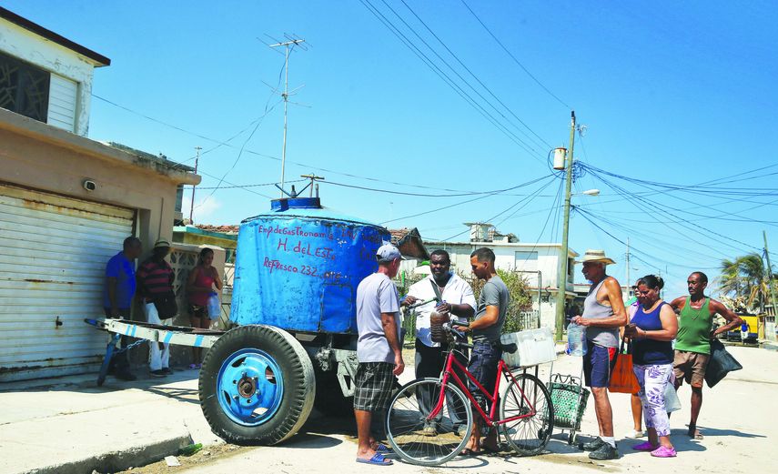 Varias personas hacen cola para comprar refsresco en la localidad de Cojímar, en La Habana.