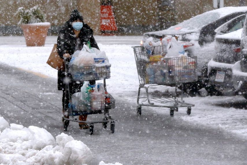 Una persona transporta comestibles en un carrito bajo una fuerte nevada en un estacionamiento en Marlborough, Massachusetts, el sábado 5 de diciembre de 2020.&nbsp;