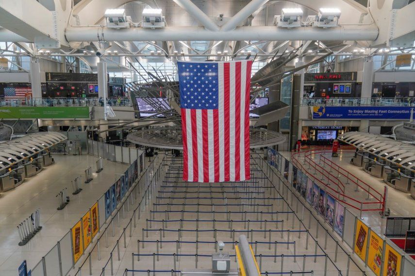 Una bandera estadounidense cuelga sobre la Terminal 1 prácticamente vacía en el Aeropuerto Internacional John F. Kennedy se Nueva York, el viernes 17 de febrero de 2023.&nbsp;