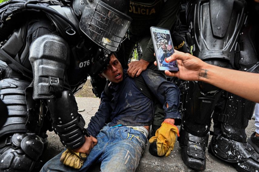 Agentes de la policía colombiana arrestan a un manifestante durante una protesta contra el gobierno en Cali, Colombia.
