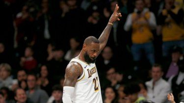 El alero de los Lakers de Los Ánngeles LeBron James recibe el reconocimiento de la fanaticada mientras se dirige al banquillo en los instantes finales del último período del juego de baloncesto ante los Nets de Brooklyn, el domingo 31 de marzo de 2024, en Nueva York.&nbsp;