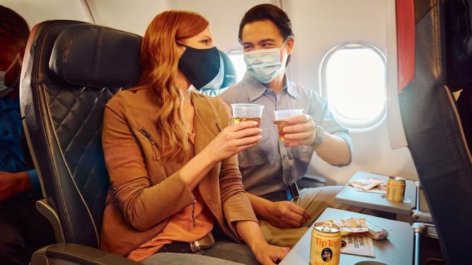 Clientes de Delta Air Lines consumen alimentos durante un vuelo de la compañía estadounidense.