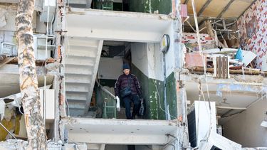 Un ucraniano desciende dentro de un edificio destruido por los bombardeos de Rusia.
