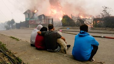 Una familia observa cómo las llamas devoran su residencia en Penco, Chile.