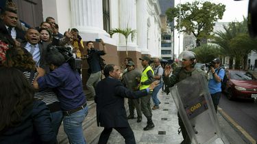 En esta imagen, tomada el 18 de junio de 2019, legisladores de la Asamblea Nacional de Venezuela forcejean con miembros de la Guardia Nacional Bolivariana en el exterior de la sede del organismo, mientras los diputados intentar dar acceso a periodistas, en Caracas, Venezuela.&nbsp; 