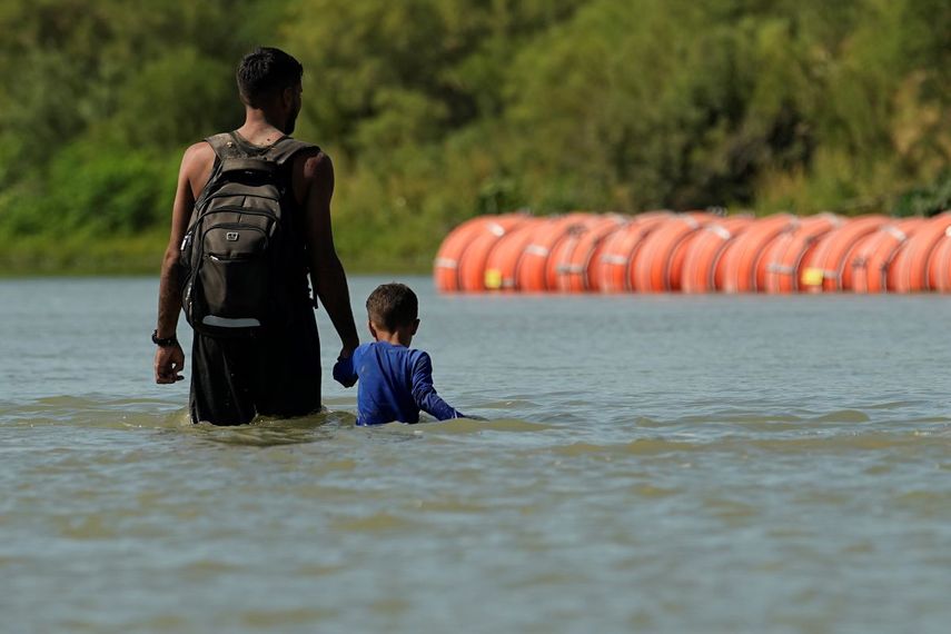 Migrantes cerca de la barrera flotante en el río Bravo cerca de Eagle Pass, Texas, el 1 de agosto de 2023.&nbsp;