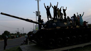 La gente paquistaní hace gestos de victoria mientras celebra después del alto el fuego entre Pakistán y la India, en Multan el 10 de mayo de 2025.