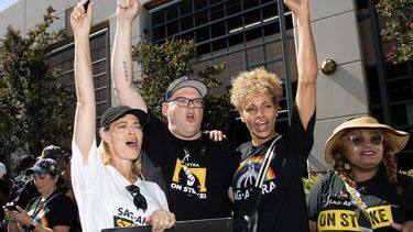 La actriz Jeri Ryan, el director ejecutivo y negociador jefe de SAG-AFTRA, Duncan Crabtree-Ireland, y la actriz Michelle Hurd protestan con los miembros del sindicato de actores frente a Warner Brothers en Burbank, California, el 3 de octubre de 2023.