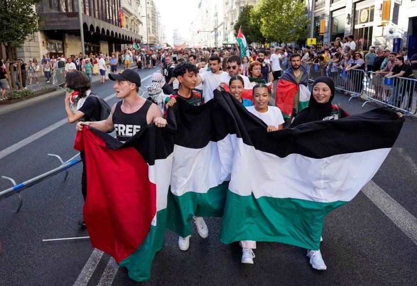 Manifestantes propalestinos sostienen una bandera del país luego de que invadieran las calles durante la Vuelta a España, el 14 de septiembre de 2025.