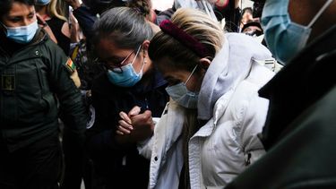 La expresidenta interina de Bolivia, Jeanine Áñez, recibe ayuda cuando es devuelta a la cárcel de mujeres de Miraflores, luego de ser tratada en una clínica privada en La Paz, Bolivia, el martes 24 de agosto de 2021