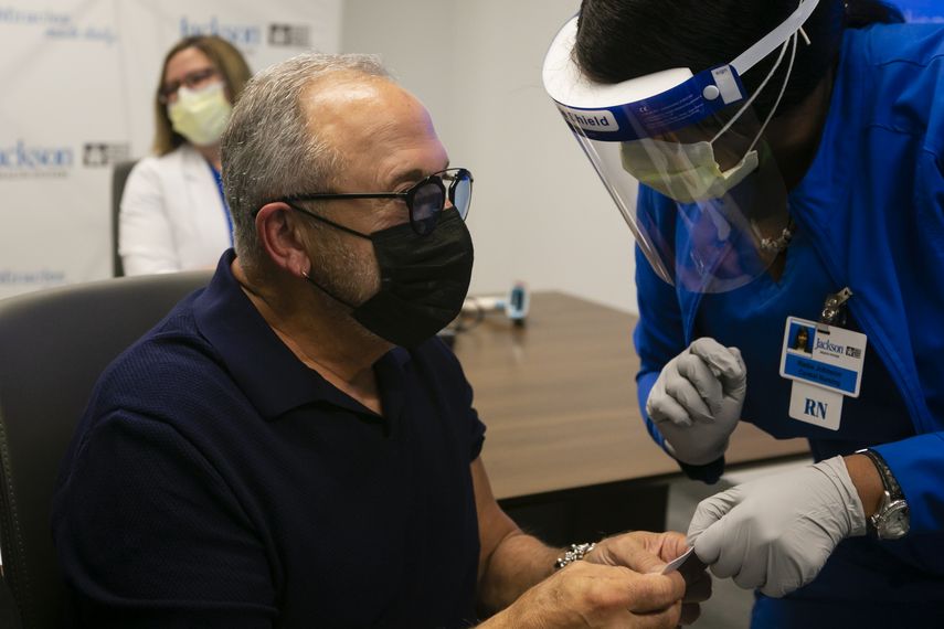 Emilio Estefan, 67, productor musical internacional, recibe su cartilla de vacunación luego de recibir su primera dosis de la vacuna Pfizer-BioNtech Covid-19 en el Centro de Rehabilitación Christine E. Lynn, en Miami, Florida, el 30 de diciembre de 2020. &nbsp;