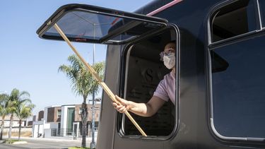 Una mujer abre una ventana en su sal&oacute;n de belleza m&oacute;vil en Tijuana, M&eacute;xico.