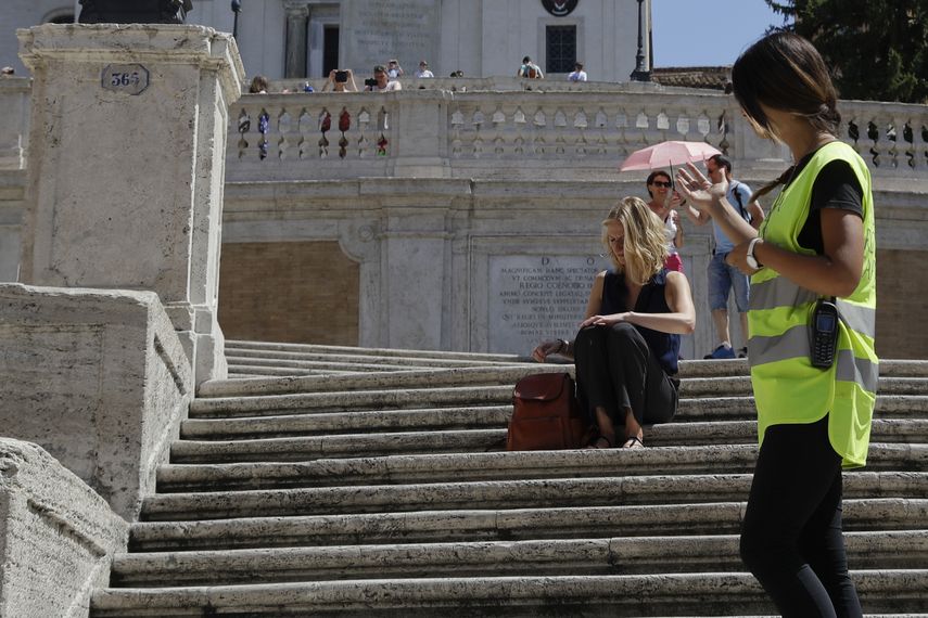 Policía pide a una mujer no sentarse en la escalinata de la Plaza de España en Roma, el miércoles 7 de agosto de 2019.&nbsp;