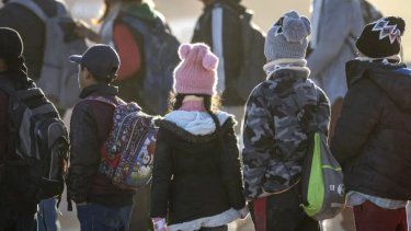 Niños inmigrantes ecuatorianos esperan ser trasladados desde la frontera entre Estados Unidos y México el 7 de diciembre de 2023 en Lukeville.