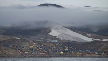 Esta fotografía tomada el 17 de agosto de 2023 muestra una vista general de Ittoqqortoormiit y su glaciar que proporciona agua potable a la aldea en el fiordo Scoresby, Groenlandia.