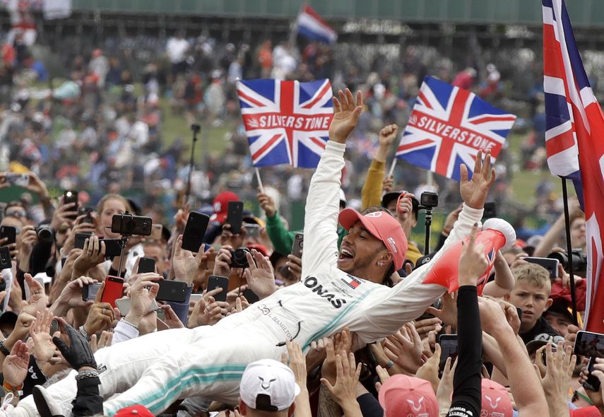 El piloto británico Lewis Hamilton, de Mercedes, festeja con los aficionados después de conquistar el Gran Premio de Gran Bretaña de la Fórmula Uno, en la pista de Silverstone, Inglaterra, el domingo 14 de julio de 2019.