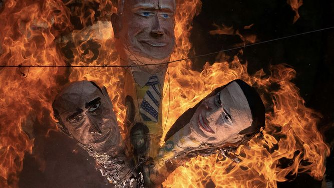 Cabezas de maniquíes que representan, de izquierda a derecha, a un político venezolano corrupto -como Maduro-, el presidente Joe Biden y la líder opositora María Corina Machado, están siendo quemados durante el tradicional ritual de Quema de Judas en el barrio San Agustín, en Caracas, el 9 de abril de 2023.