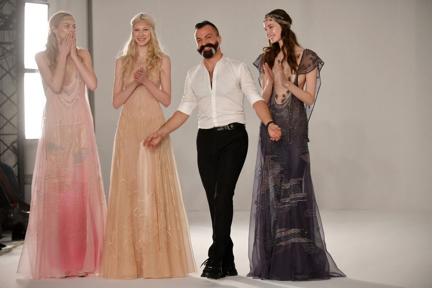 El diseñador de moda francés Julien Fournie posa con modelos después de la presentación de su colección Primavera-Verano 2023-2024 de Alta Costura durante la Semana de la Moda de París el 24 de enero de 2023.