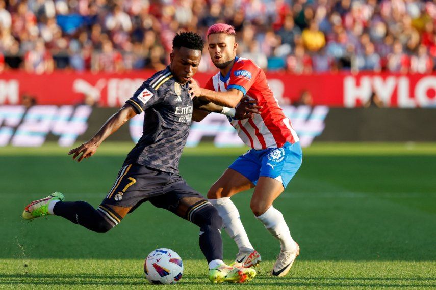 Vinicius Junior (izquierda) del Real Madrid pugna el balón con Yan Couto de Girona en el partido de la Liga española, el 30 de septiembre de 2023.