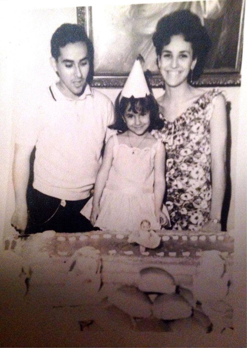 Maylén, de niña, celebrando su cumpleaños junto a sus padres.