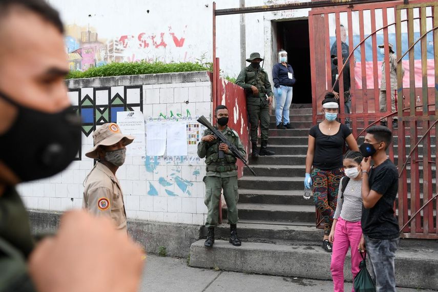 Fuerzas de seguridad vigilan un centro de votación durante las elecciones para elegir a los miembros de la Asamblea Nacional en Caracas, Venezuela, el domingo 6 de diciembre de 2020, unas elecciones caracterizadas por el abstencionismo. En la foto se observan custodios y funcionarios, pero no votantes.