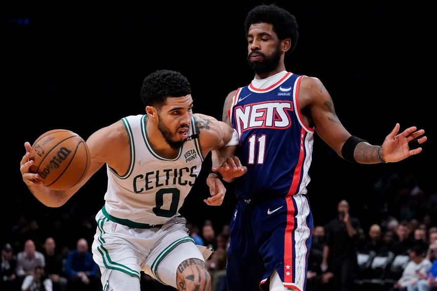 El alero de los Celtics de Boston Jayson Tatum es defendido por el base de los Nets de Brooklyn Kyrie Irving, en la segunda mitad del cuarto juego de la serie de playoffs de primera ronda en la NBA, el lunes 25 de abril de 2022, en Nueva York.